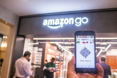 Ein Kunde zeigt eine Smartphone-App vor einem Amazon Go-Laden.